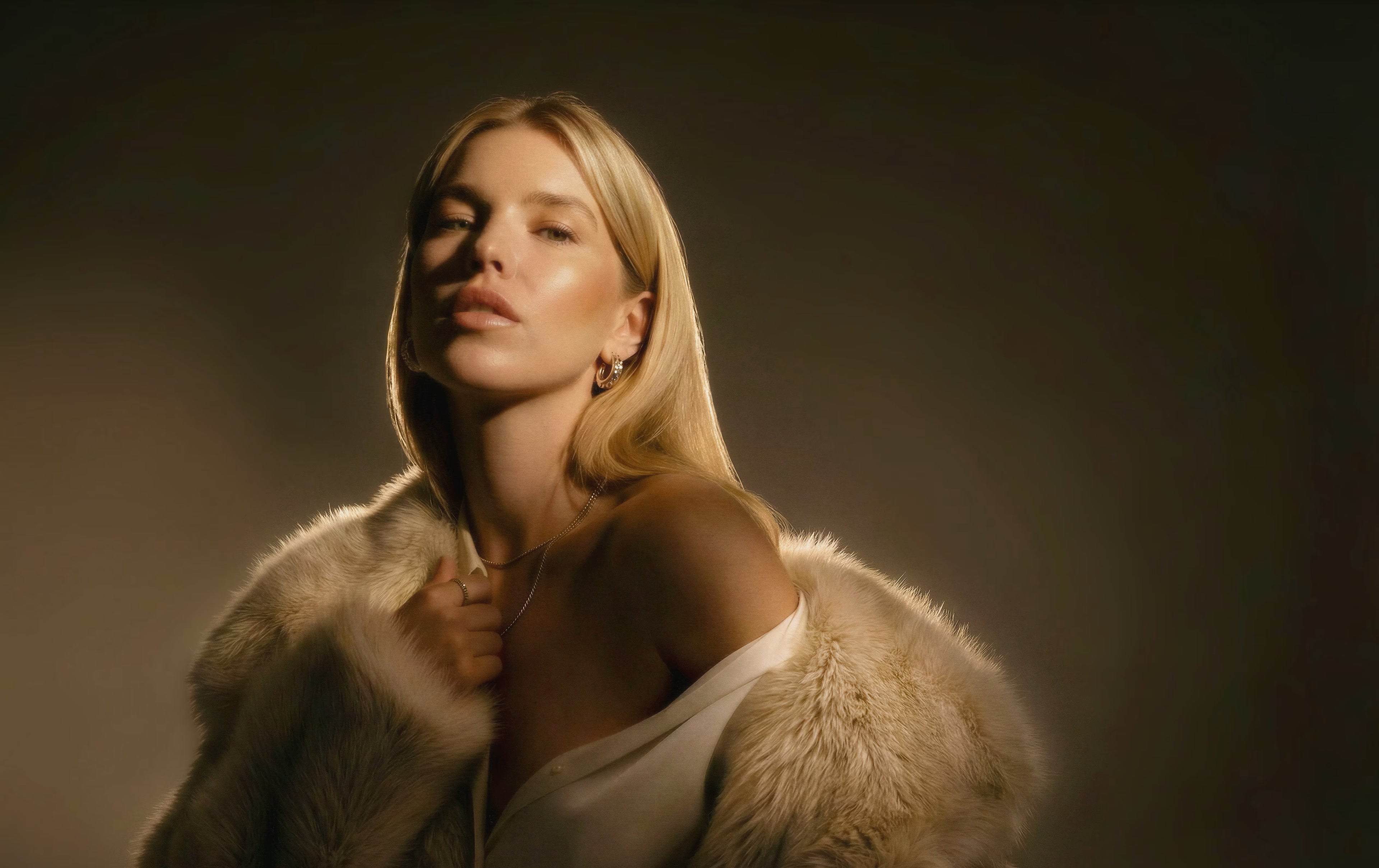 Woman wearing a fur coat against a dark background